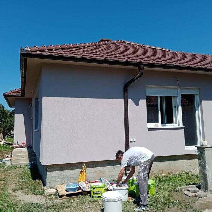 Moler meša lepak u kanti ispred kuće